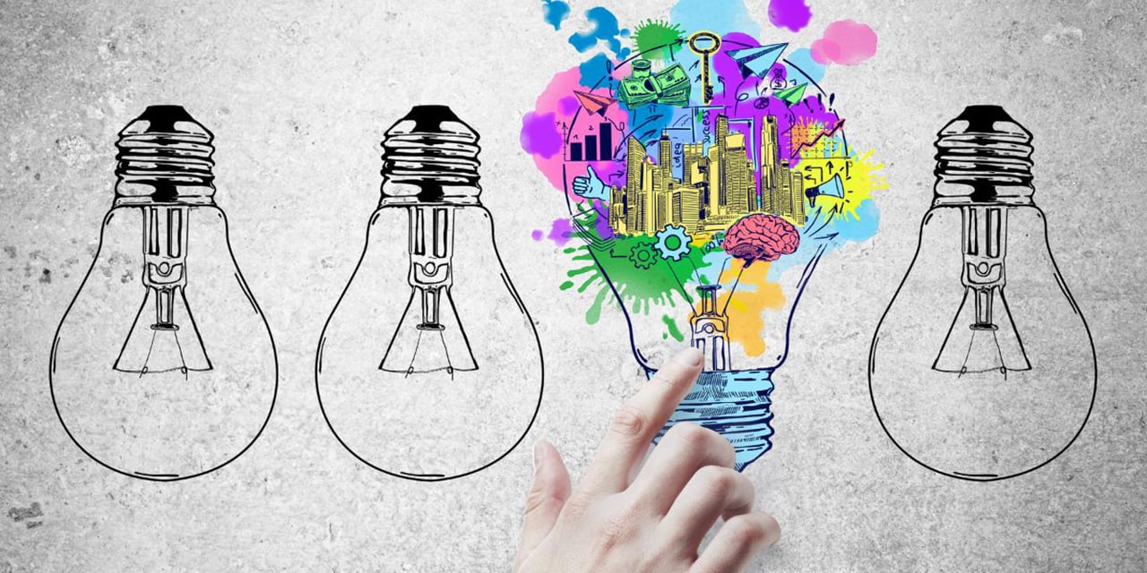 Hand touching one of four lightbulb drawings on a gray background.